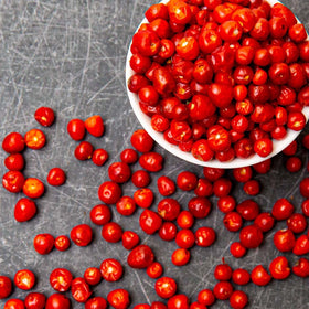 Chiltepin peppers in a bowl, offering earthy smokiness for tacos and stews.
