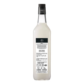 1883 MAISON ROUTIN almond syrup being poured into a glass.