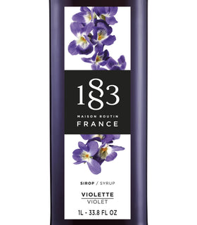 1883 MAISON ROUTIN violet syrup pouring into glass highlights versatile use