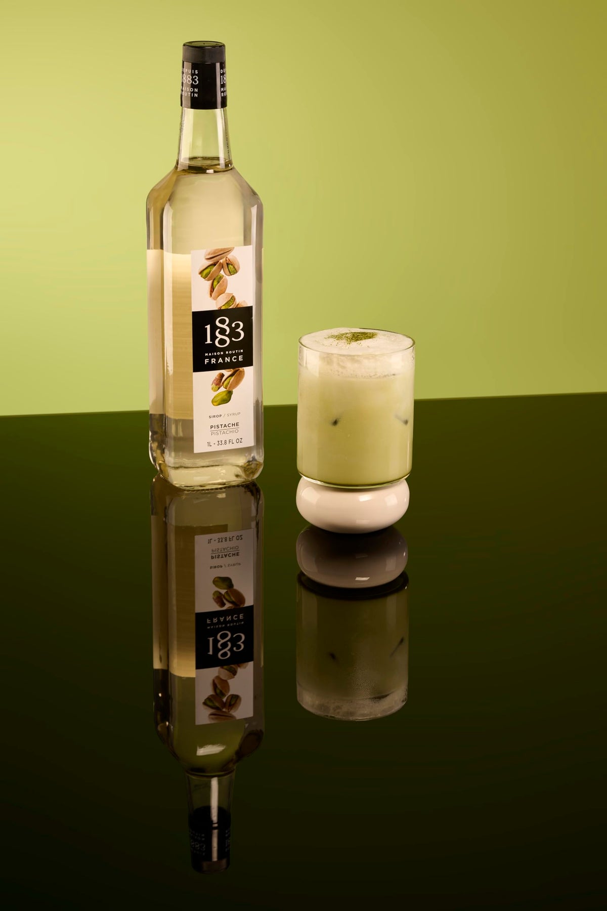 1883 Pistachio syrup being poured to enhance beverages with nutty notes.