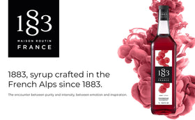 1883 Raspberry Syrup being poured enriches a refreshing drink.
