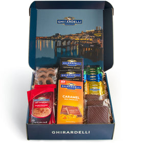A Gift Inside Ghirardelli celebration box cover with navy presentation for festive gifting.
