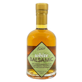 Acetaia Cattani White Balsamic Vinegar bottle on a wooden board, ideal for fresh salads.