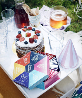A steaming cup beside the gift box evokes warm, inviting tea moments.