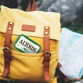 Altoids Spearmint mints spill from tin, signaling fresh breath opportunities.