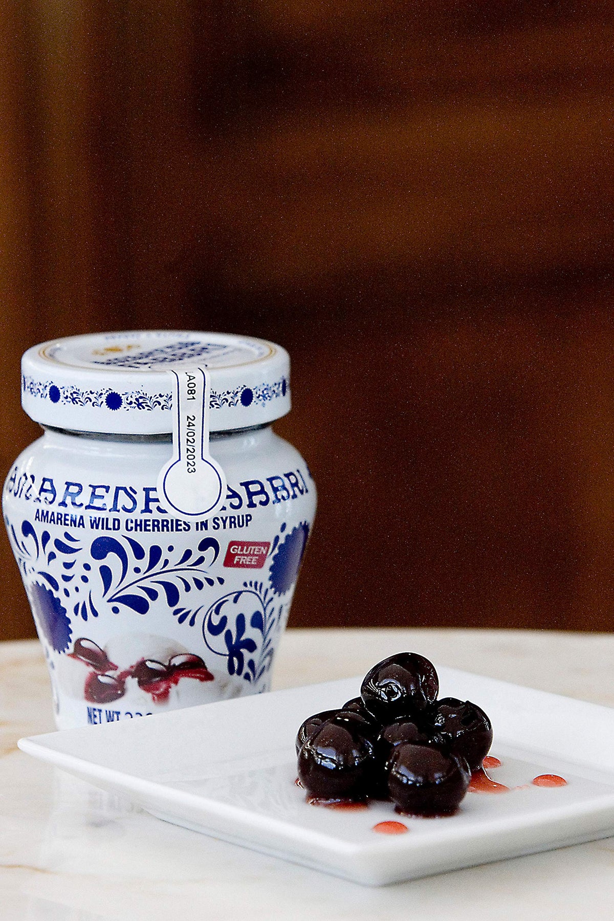 Close-up jar of syrup-coated Amarena cherries for refined dessert garnishes.