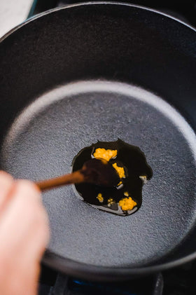 Pouring Amish Country Popcorn Coconut Oil to coat popcorn kernels with aroma and shine.