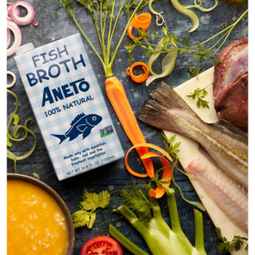 Aneto Fish Broth ingredients close-up with fresh vegetables.