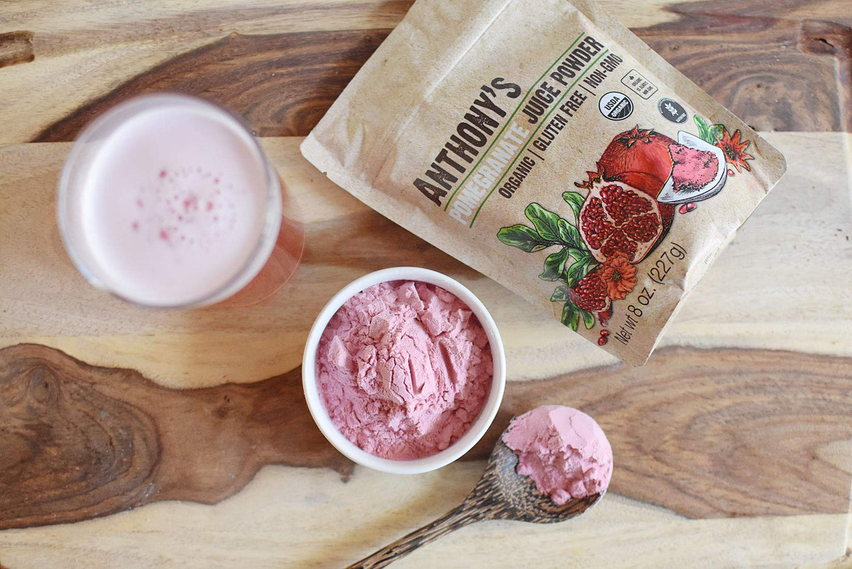 Sprinkling Anthony's Organic Pomegranate Powder over yogurt for flavor.