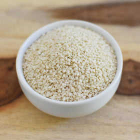 Anthony's Organic Hulled Sesame Seeds being poured, perfect for toasting and flavor boost