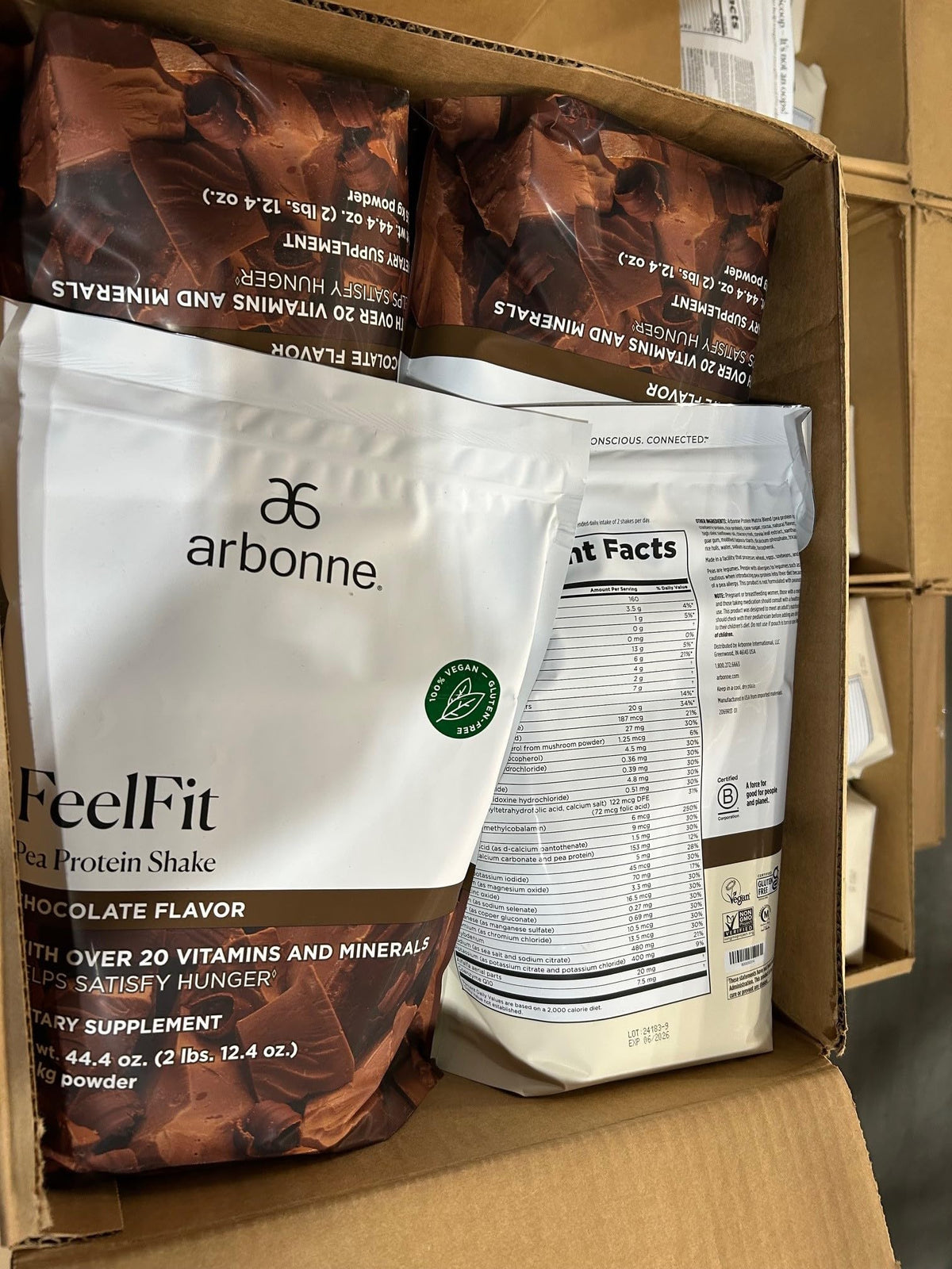 Arbonne EssentialMeal shake with a rich chocolate foam texture in a glass.