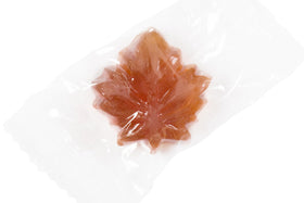 Close-up of Artisan Owl Maple Drops, amber candies with slow-melt texture.