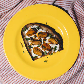 Closeup of Ati Manel mussels in spicy pickled sauce can showcasing texture.