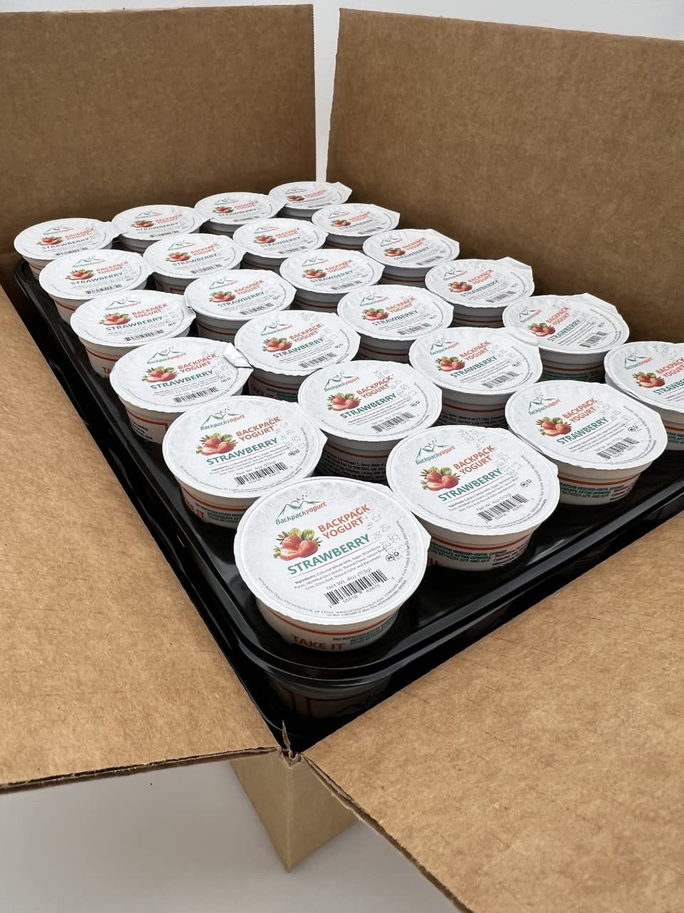 Backpack Yogurt Strawberry 4 oz cup shown in a lunchbox for on-the-go real fruit snack.