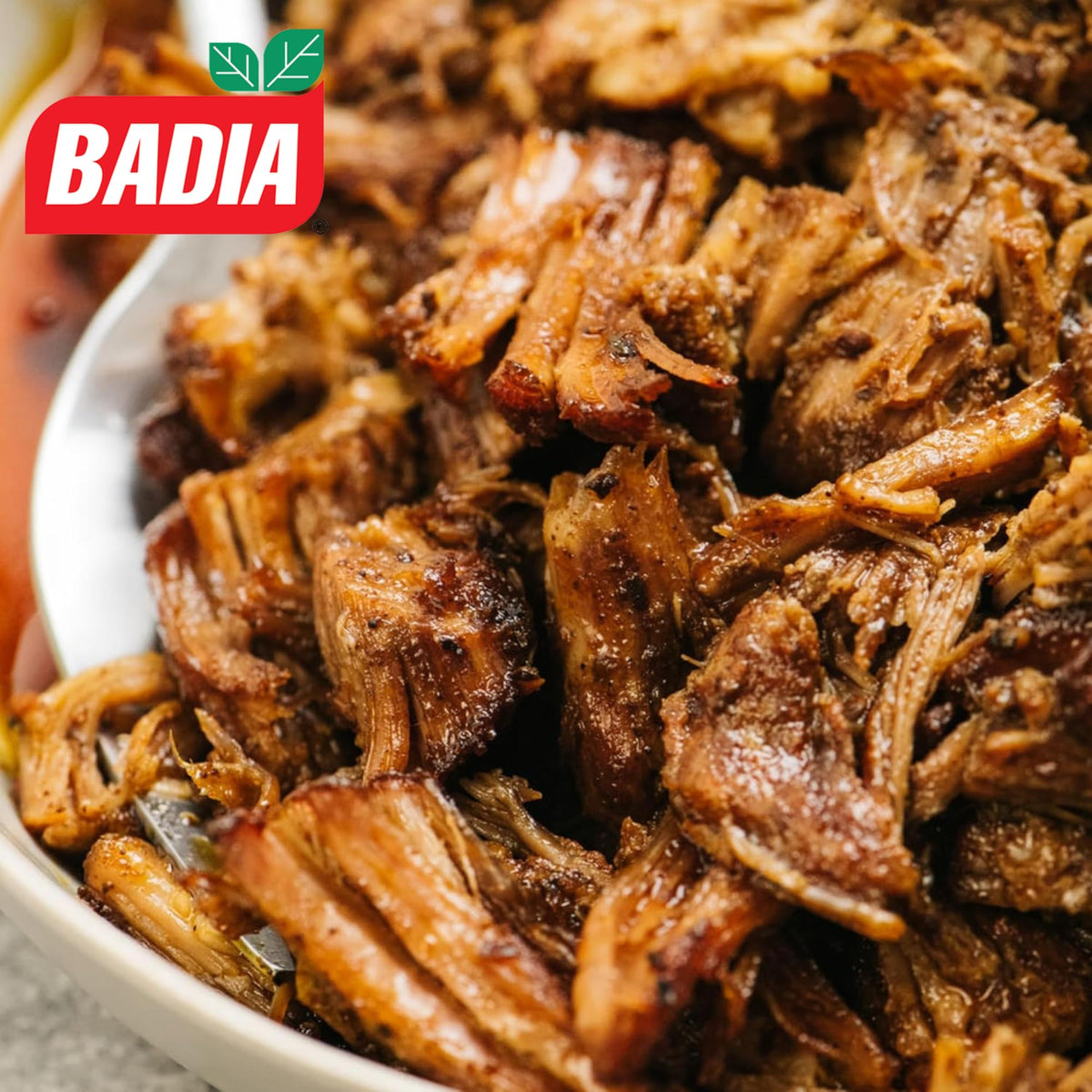Pouring Badia Sour Orange Marinade, tangy citrus glaze adds quick flavor boost.
