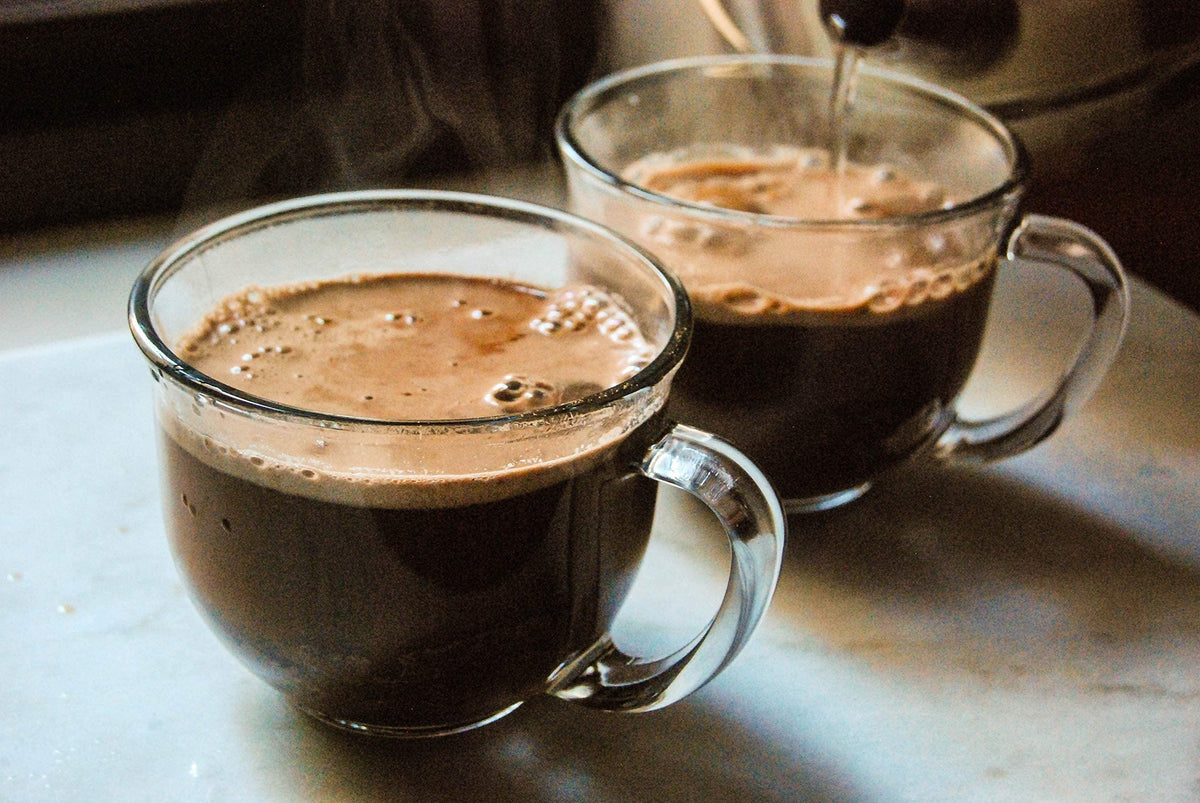 Bare Life Coconut Hot Cocoa being poured into hot water for a quick cup