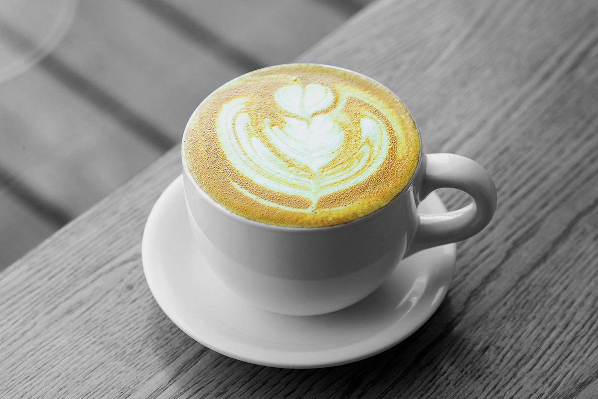 Golden Chai poured into a glass with creamy foam.