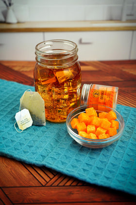 Bear Necessities handcrafted sugar cubes beside a glass for an Old Fashioned or Aperol Spritz.