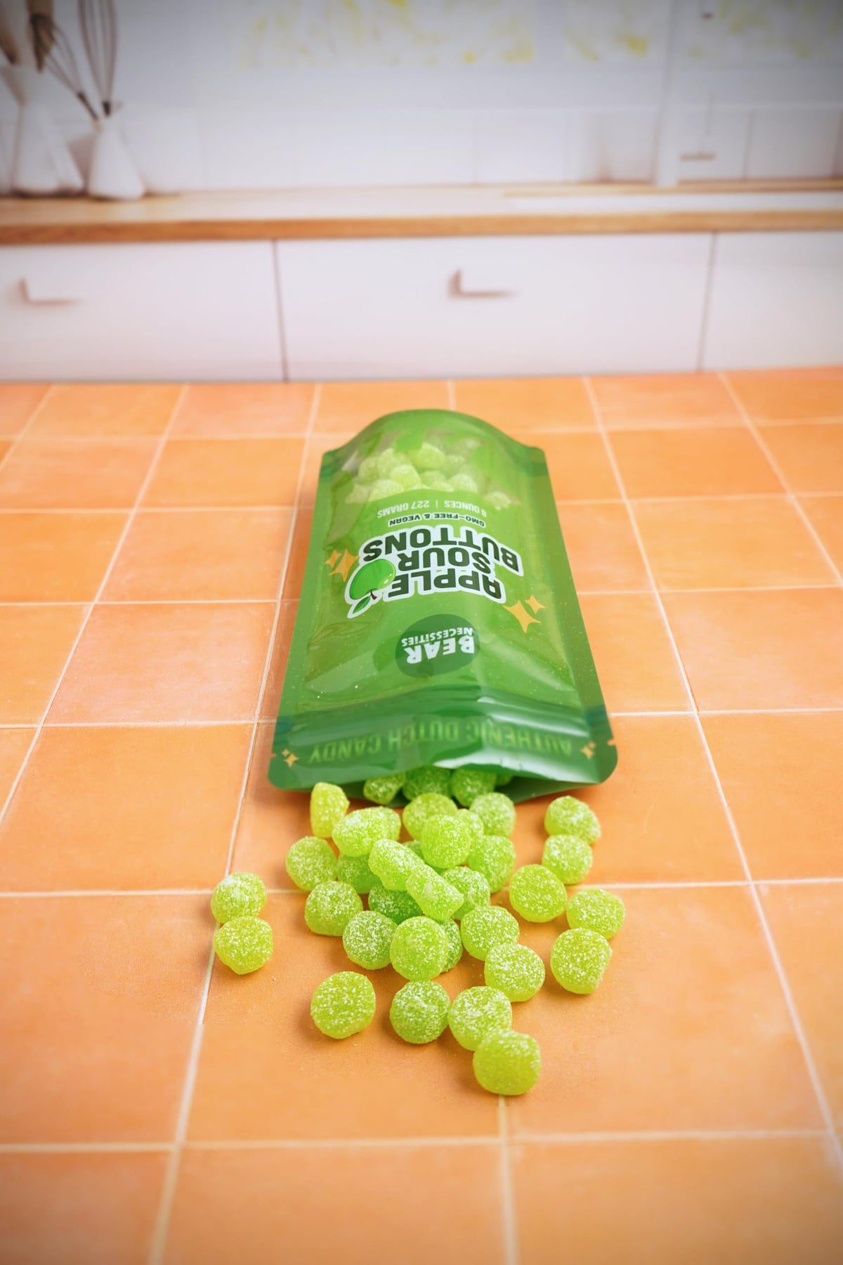 Bear Necessities Sour Buttons apple gummy close-up demonstrates resealable bag preserving freshness.