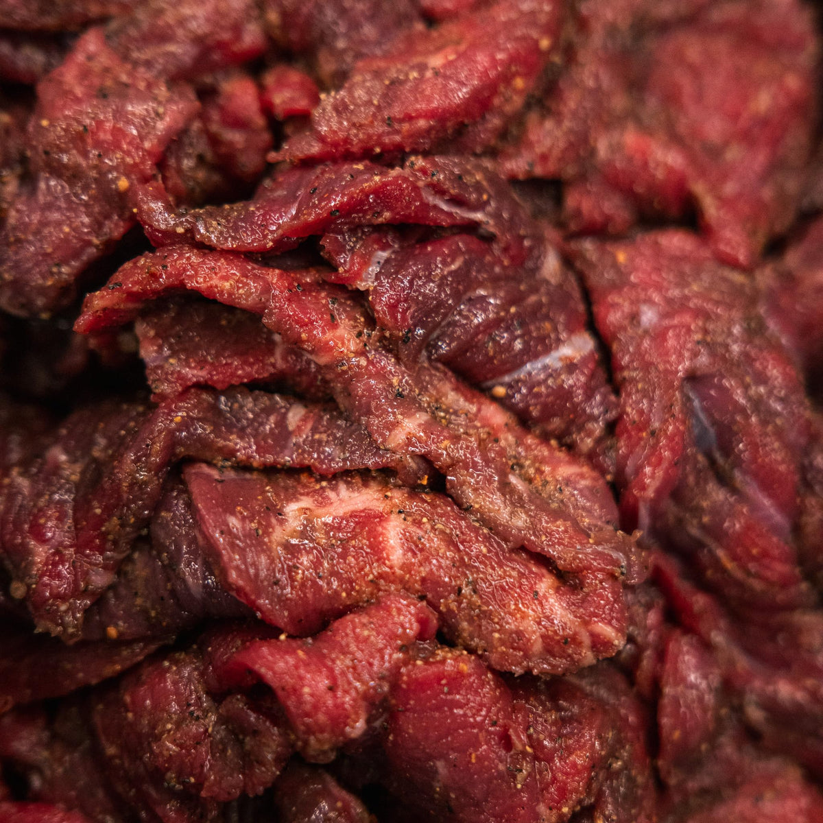Meat on rack with Bearded Butchers seasoning ready for smoking or drying.
