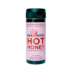 Bee Dolce Hot Honey pour showcasing sweet heat on pizza and marinades.