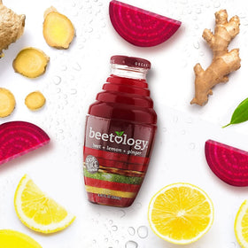 Beetology juice bottle pour into glass, ideal for refreshing smoothies and mocktails.