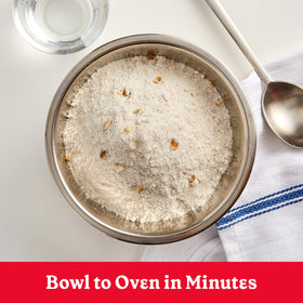 Two warm muffins on a plate with butter.