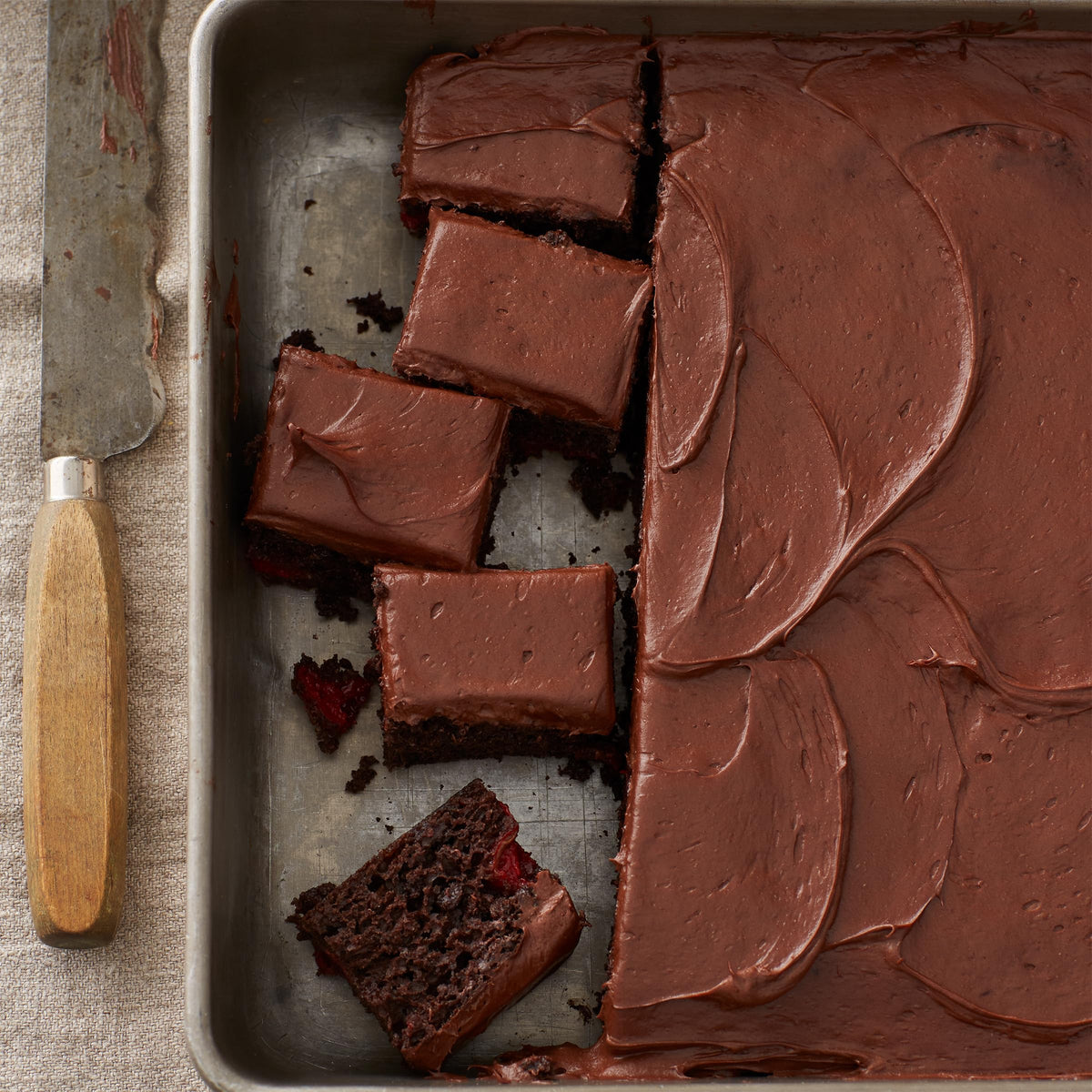 Gluten-free dark chocolate frosting spread on a layered cake