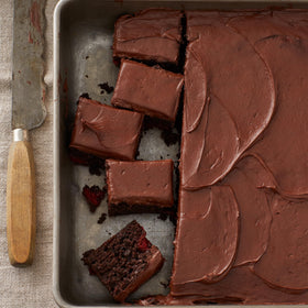 Gluten-free dark chocolate frosting spread on a layered cake