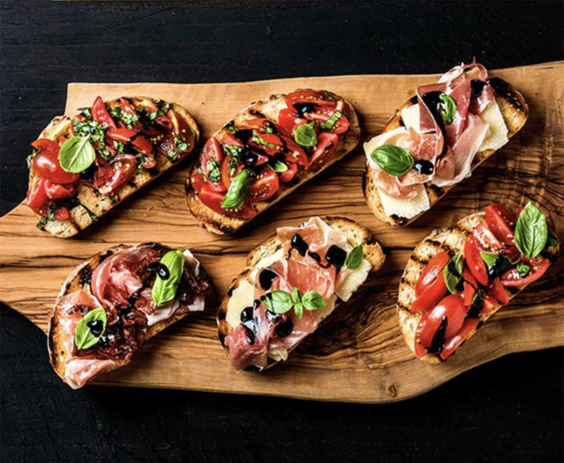 Blazing Bella bottle beside cheese board, pairs well with meats, cheeses, and bread