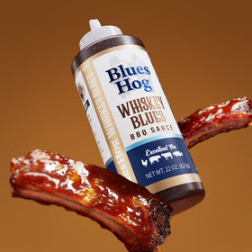 Blues Hog Whiskey Blues BBQ Sauce on grilled ribs highlighting bourbon notes.