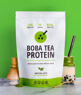 Measuring spoon beside Boba Tea Protein Matcha Latte for precise scooping.