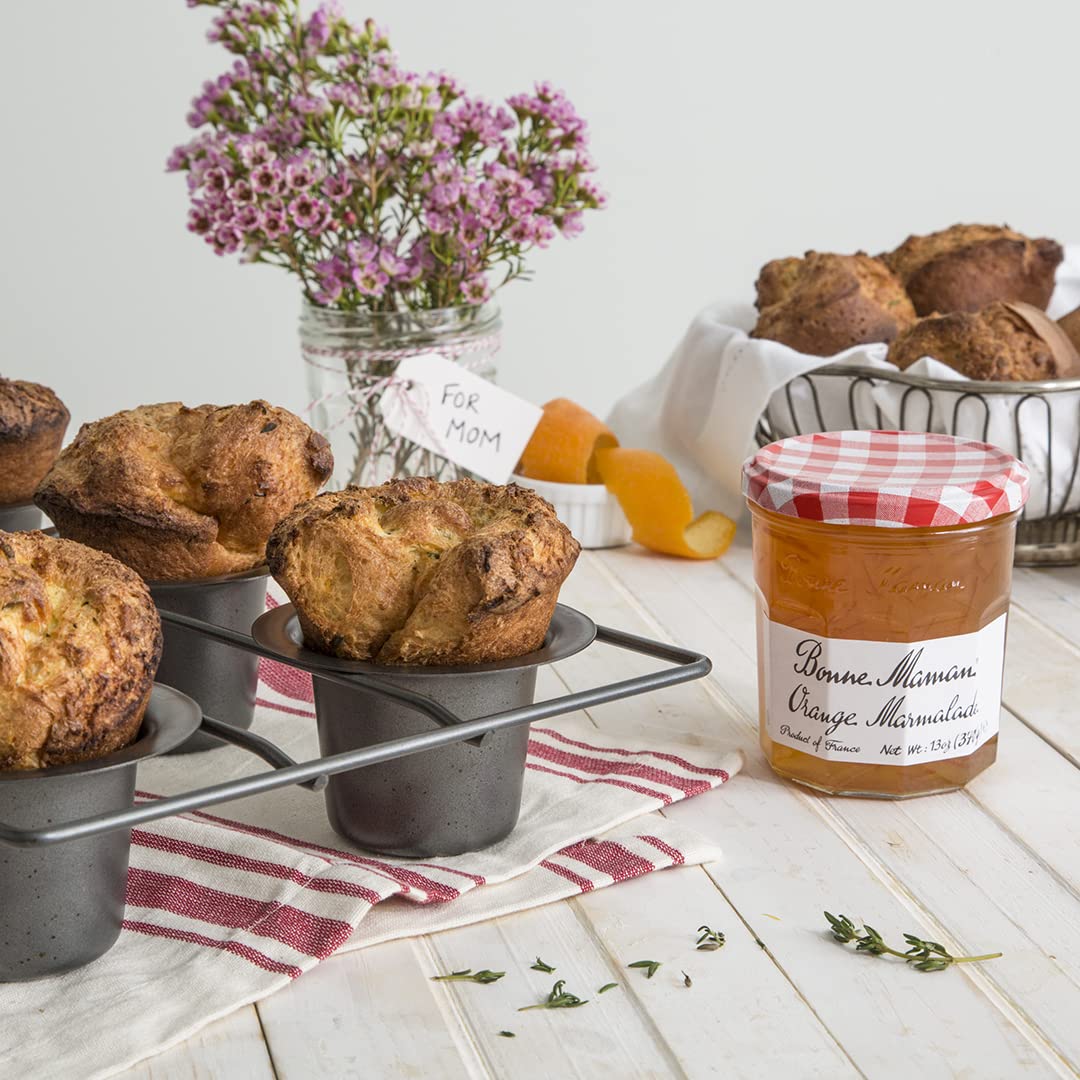 Pouring Bonne Maman orange marmalade to glaze pastries or toast.