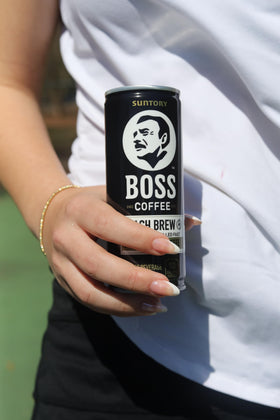 BOSS Coffee can being poured over ice with strong aroma.