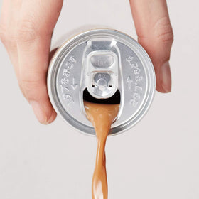 BOSS Coffee being poured into a glass to reveal aroma and smooth finish.