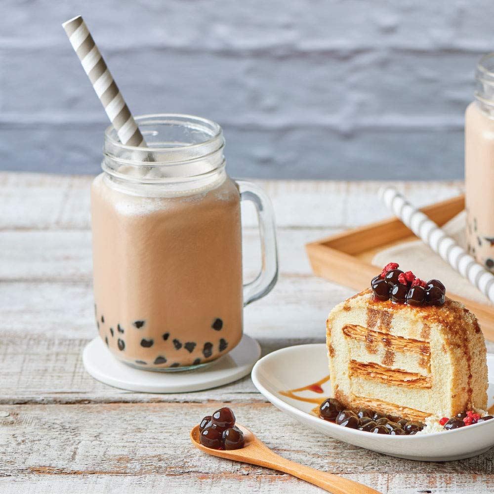 Bossen prepared bubble tea in a glass with vibrant color and foam.
