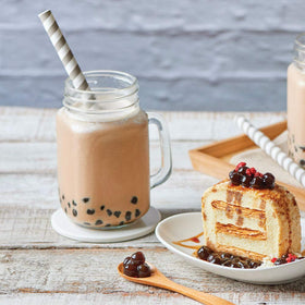 Bossen prepared bubble tea in a glass with vibrant color and foam.