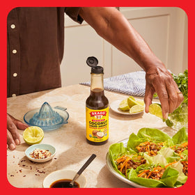  Glass bottle of Bragg Coconut Aminos on kitchen shelf