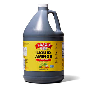Bragg Liquid Aminos bottle pouring, gluten-free seasoning for stir-fries.
