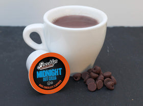 A steaming cup of Brooklyn Beans Midnight cocoa releasing a rich chocolate aroma