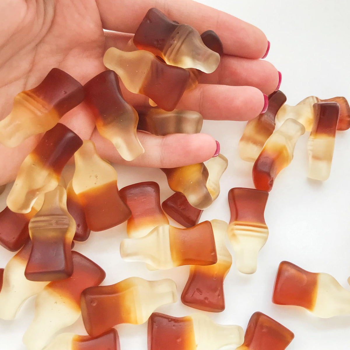 Soft, chewy cola bottles on a serving tray during a gathering.