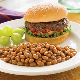 Bush's Best Country Style Baked Beans served with burgers on a plate.