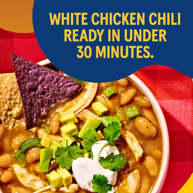 Simmering pan with Bush's Best White Chili Magic Starter offers cozy meal prep.
