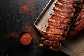 Butt Rub Bad Byron's Barbeque Seasoning on chicken thighs for flavorful smoke.