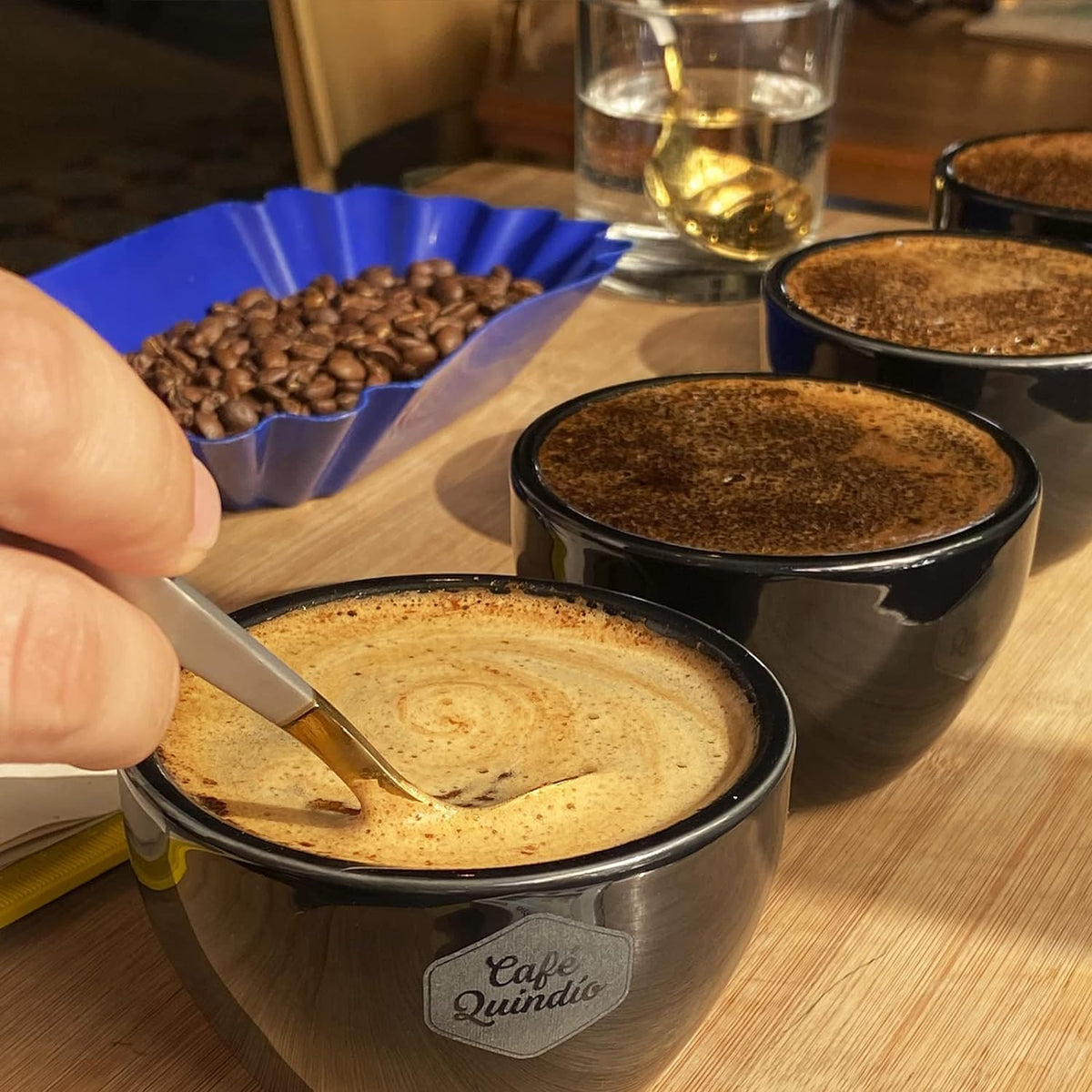 Cafe Quindio medium roast shown with a tasting mug for enjoyment.