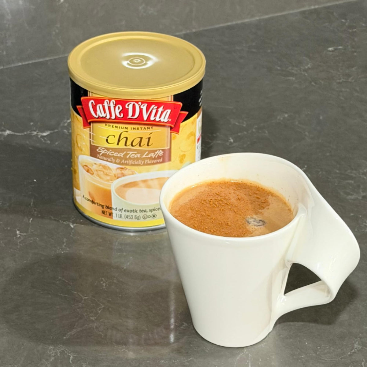 Steaming milk blends with Caffe D'Vita Spiced Chai Latte Mix for a cozy aroma.