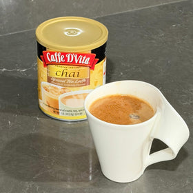 Steaming milk blends with Caffe D'Vita Spiced Chai Latte Mix for a cozy aroma.