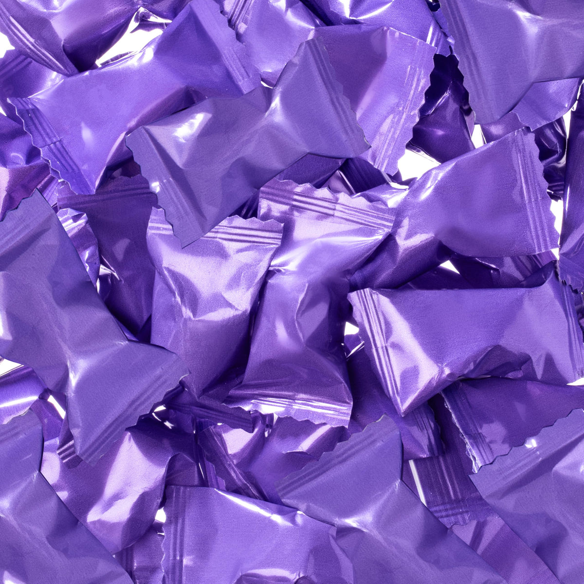 White mints with violet wrappers ready for elegant party favors