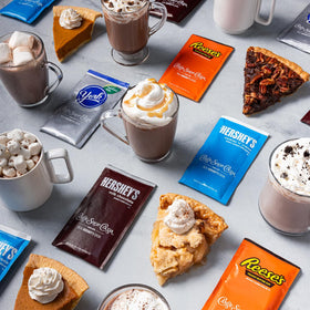 Boxed 24-pack display of Candy Shop Cocoa Mix varieties on shelf.
