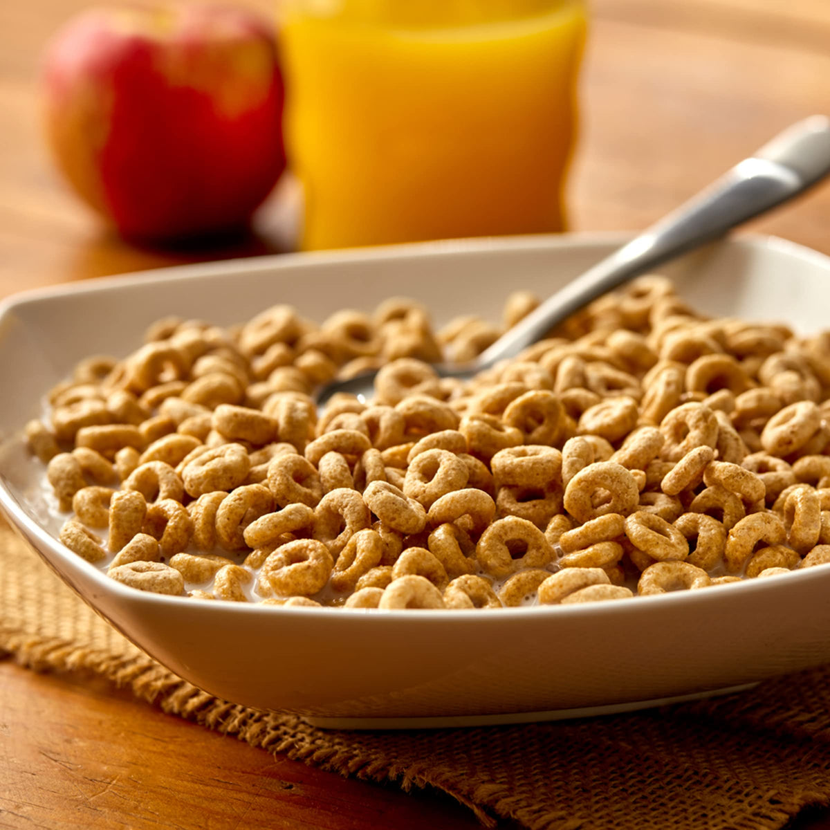 Cheerios pouring milk into cup for quick breakfast ritual.